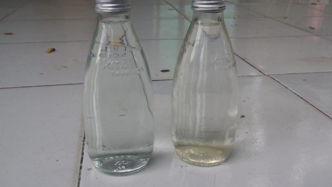 Tampak perbedaan kualitas air botol kiri yang tampak jernih adalah air sumur dan botol kanan yang tampak keruh adalah air dari PDAM Intan Banjar