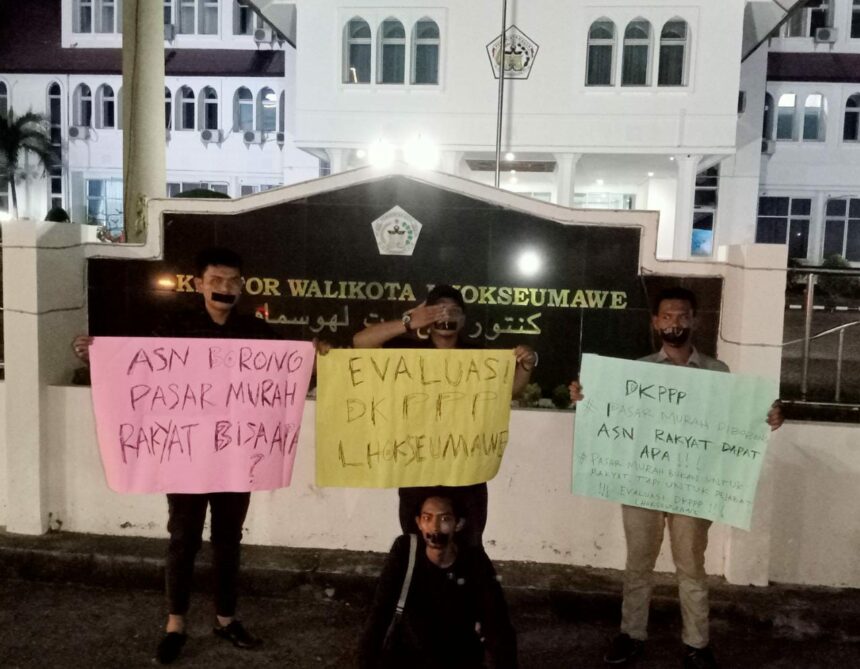 Aksi Damai Gerakan Muda Aceh (GeMA) di depan Kantor Wali Kota Lhokseumawe terkait polemik pasar murah. Senin (03/07/2023) malam. (Foto: Raja)